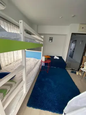 a bedroom with a bunk bed and a blue rug at Takemura Building 302 in Tokyo