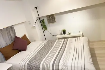 a bedroom with a large white bed in a room at Takemura Building 104 in Tokyo