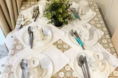 a table with white plates and silver utensils on it at Takemura Building 104 in Tokyo