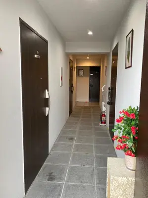 a hallway of a hotel with a door and flowers at Takemura Building 303 in Tokyo