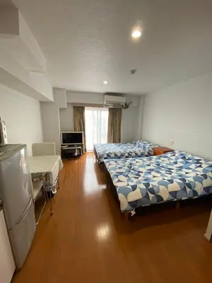 a bedroom with two beds and a television in it at Takemura Building 3F in Tokyo