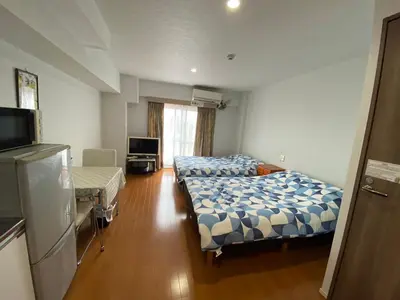 a hotel room with two beds and a television at Takemura Building 3F in Tokyo
