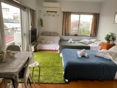 a bedroom with two beds and a living room at Takemura Building 305 in Tokyo