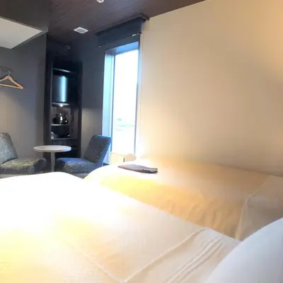 two beds in a room with a window at JHotelTokyoGEO in Tokyo