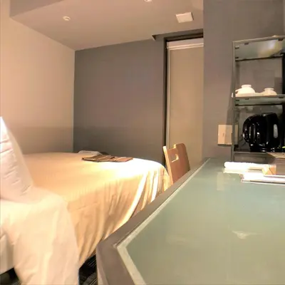 a room with a bed and a glass table at JHotelTokyoGEO in Tokyo