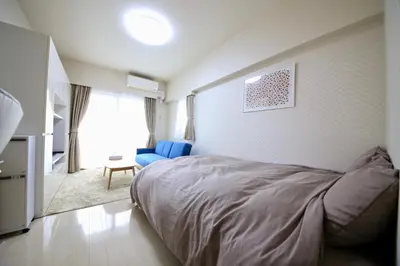 a bedroom with a bed and a blue couch in it at NorthRiverSKY in Tokyo