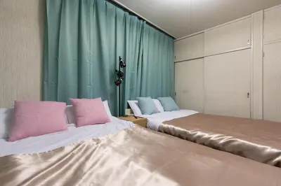 two beds with pink and blue pillows in a room at Shinjuku Japanese-style two storey house in Tokyo