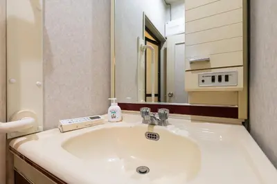 a bathroom with a sink and a mirror at Shinjuku Japanese-style two storey house in Tokyo