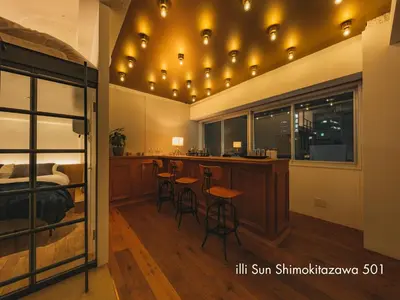 a room with a bed and a bar with stools at illi Sun Shimokitazawa in Tokyo