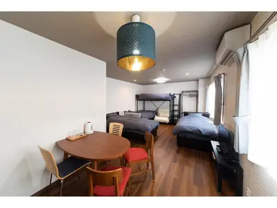 a room with a table and a room with two beds at Oyado Kien Ryogoku in Tokyo