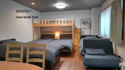 a bedroom with two bunk beds and a table and a couch at Oyado Kien Ryogoku in Tokyo