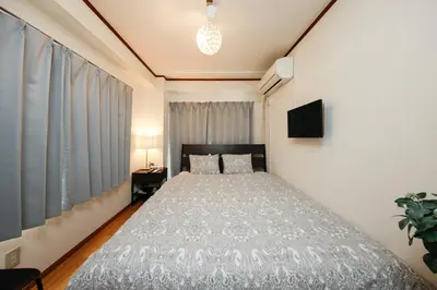 a bedroom with a bed and a television in it at Ikebukuro Apartment by Tranova in Tokyo