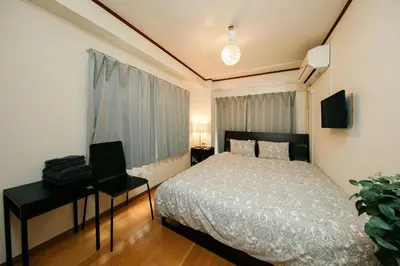 a bedroom with a bed and a desk with a laptop at Ikebukuro Apartment by Tranova in Tokyo