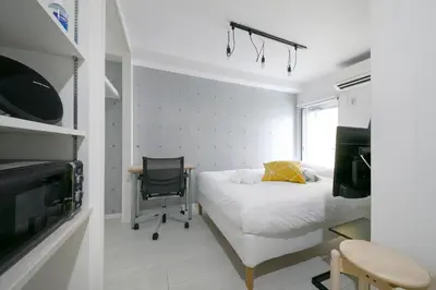 a bedroom with a bed and a desk and a chair at Real Kinshi in Tokyo