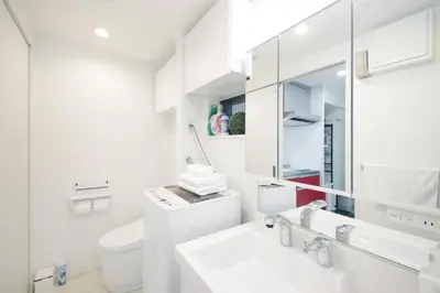 a white bathroom with a sink and a mirror at Real Kinshi in Tokyo