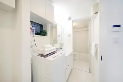 a white bathroom with a sink and a mirror at Real Kinshi in Tokyo