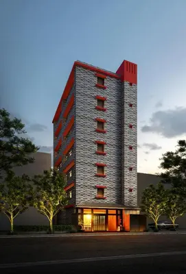 a tall brick building with a red roof at Petit Grande Miyabi in Tokyo