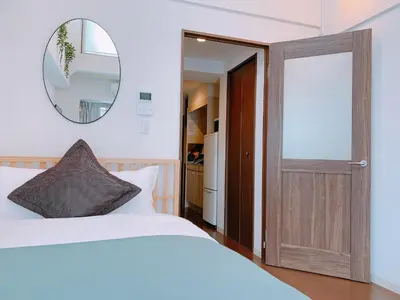 a bedroom with a bed and a mirror and a door at Dash Living Higashi Azabu in Tokyo