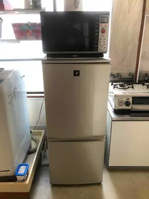 a microwave on top of a refrigerator in a kitchen at Cozy room in Itabashi in Tokyo