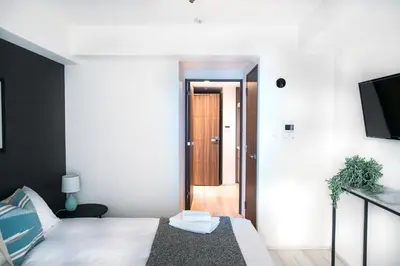 a bedroom with a bed and a door to a hallway at Dash Living Nihonbashi in Tokyo