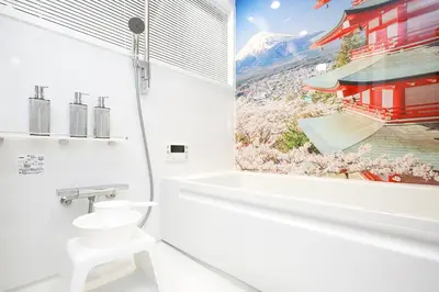 a bathroom with a toilet and a bath tub and a window at SAKURANOMA in Tokyo
