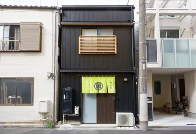 a black house with a yellow banner over the door at SAKURANOMA in Tokyo
