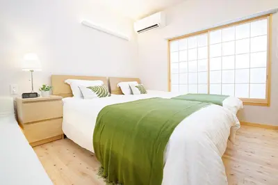 a bedroom with two beds and a large window at SAKURANOMA in Tokyo