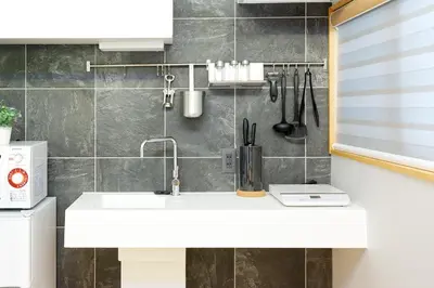 a bathroom with a white sink and a wall at SAKURANOMA in Tokyo