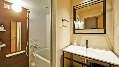 a bathroom with a sink and a mirror and a shower at Stay SAKURA Tokyo Shinjuku Hyakukura in Tokyo