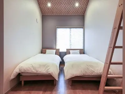two beds in a room with a window at YADOYA Iriyaan in Tokyo