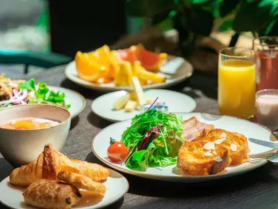 a wooden table with plates of food and drinks at Tokyo Bay Shiomi Prince Hotel in Tokyo