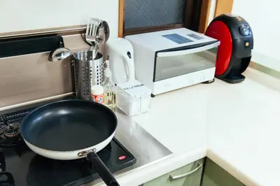 a pan sitting on top of a stove in a kitchen at \u307e\u308b\u307e\u308b\u8cb8\u5207,\u7fbd\u7530\u7a7a\u6e2f\u304b\u3089\u4e00\u756a\u8fd1\u3044yu`s house in Tokyo