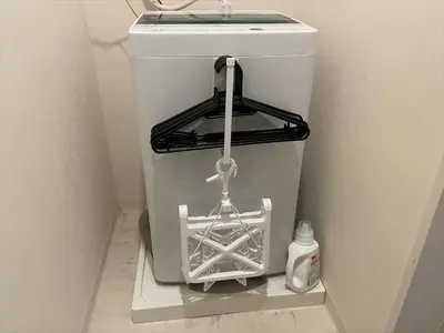 a white trash can in a corner of a bathroom at COTO Tokyo Shibuya 7 in Tokyo