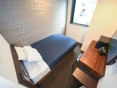a small room with a bed and a table at HOTEL LiVEMAX Nihonbashi Koamicho in Tokyo