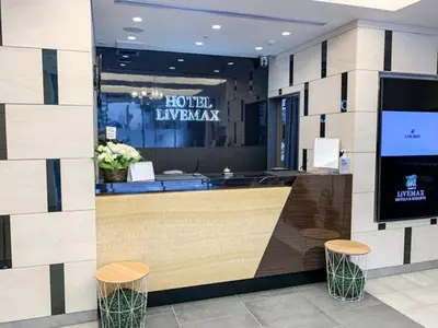 a hotel lobby with a counter and stools at HOTEL LiVEMAX Nihonbashi Koamicho in Tokyo
