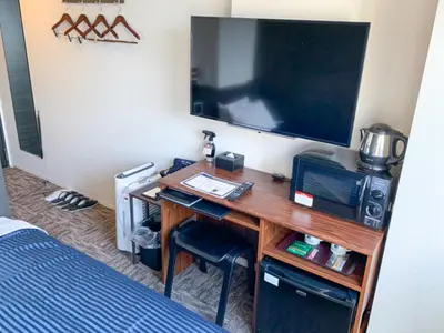 a room with a desk with a tv and a bed at HOTEL LiVEMAX Shinjuku Kabukicho in Tokyo