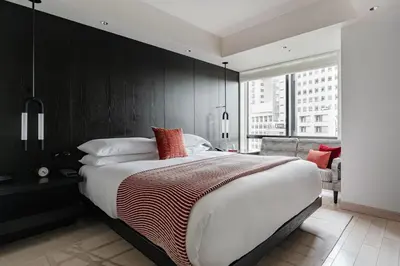 a bedroom with a large bed with a black wall at Kimpton Shinjuku Tokyo by IHG in Tokyo