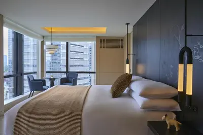 a bedroom with a large bed with a view of the city at Kimpton Shinjuku Tokyo by IHG in Tokyo