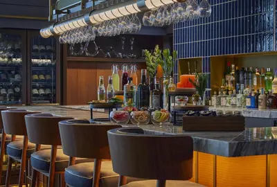 a bar with chairs and a counter with drinks at Kimpton Shinjuku Tokyo by IHG in Tokyo