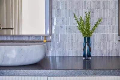 a vase with a plant in it next to a sink at Kimpton Shinjuku Tokyo by IHG in Tokyo