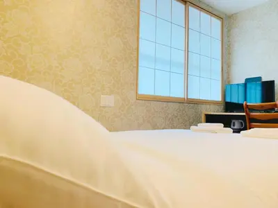 a bedroom with a large white bed and a window at Allcomein Hotel Akihabara in Tokyo