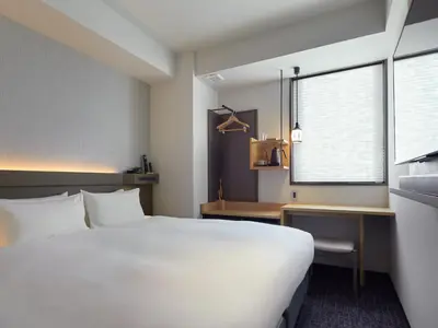 a bedroom with a bed and a desk and a window at Agora Tokyo Ginza in Tokyo