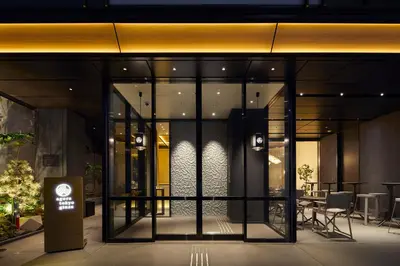 a building with glass doors and a table and chairs at Agora Tokyo Ginza in Tokyo