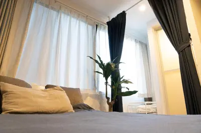 a bedroom with a bed with a plant in front of a window at Higashi Shinagawa Apartment by Tranova in Tokyo
