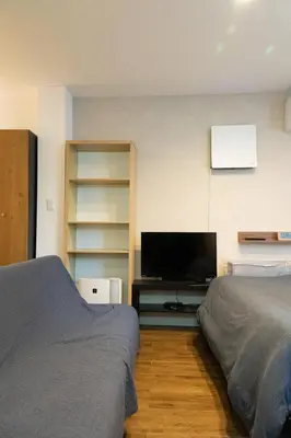 a bedroom with two beds and a flat screen tv at Higashi Shinagawa Apartment by Tranova in Tokyo