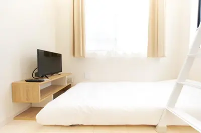 a bedroom with a bed and a television on a stand at Nano North Shinjuku Apartment by Tranova in Tokyo