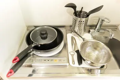 a kitchen sink with a frying pan and other kitchen utensils at Nano North Shinjuku Apartment by Tranova in Tokyo