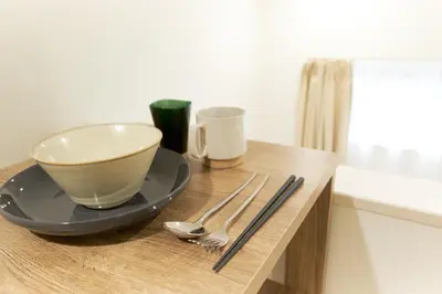 a table with a cup and a bowl on a plate at Nano North Shinjuku Apartment by Tranova in Tokyo