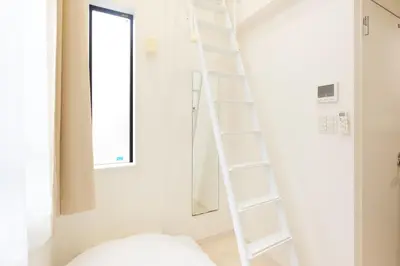 a white ladder in a white room with a window at Nano North Shinjuku Apartment by Tranova in Tokyo