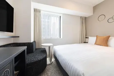 a hotel room with a bed and a chair at Hotel Vista Tokyo Tsukiji in Tokyo